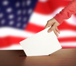 Hand with ballot and box on Flag of USA